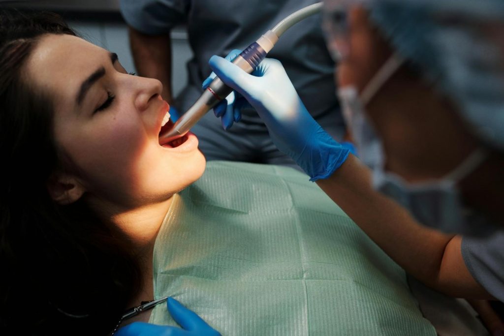 Patient receiving professional teeth cleaning at dental clinic