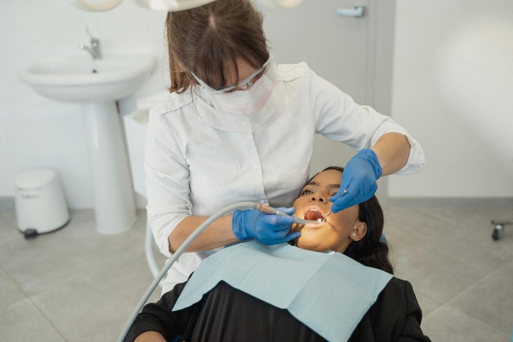 Dentist performing oral examination on patient with dental tools in a modern clinic