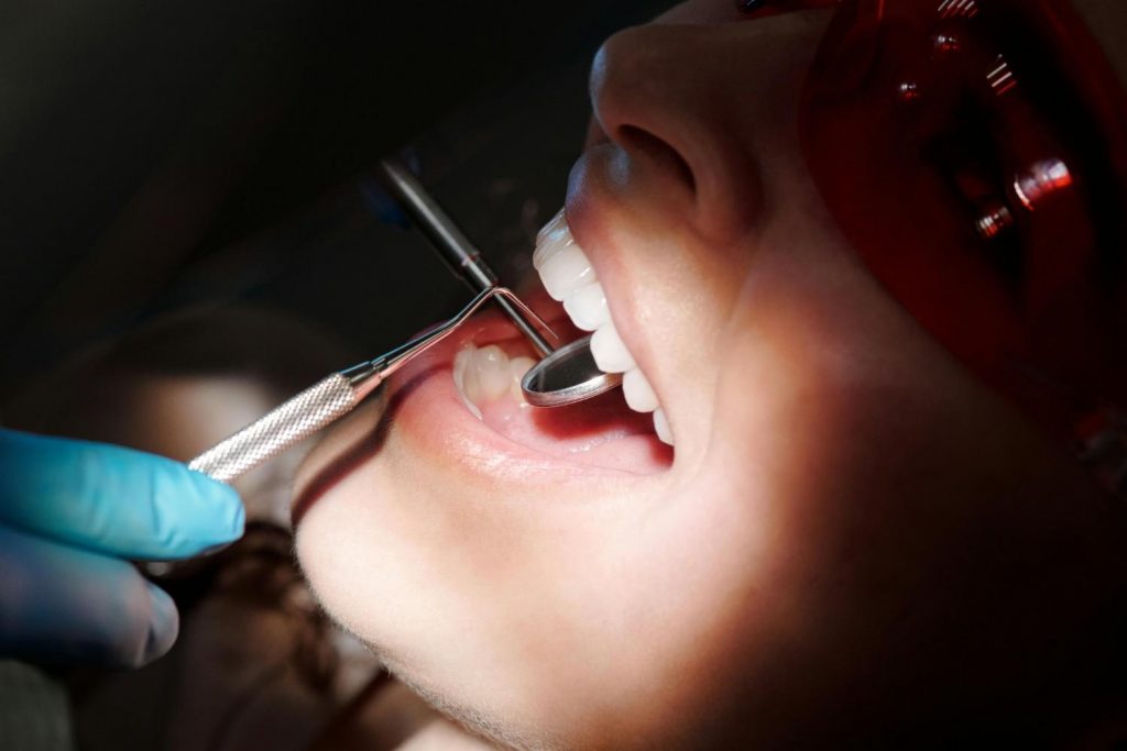 Dentist examining patient’s teeth for teeth cleaning