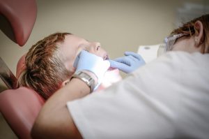 Dentist examining child’s teeth during dental checkup