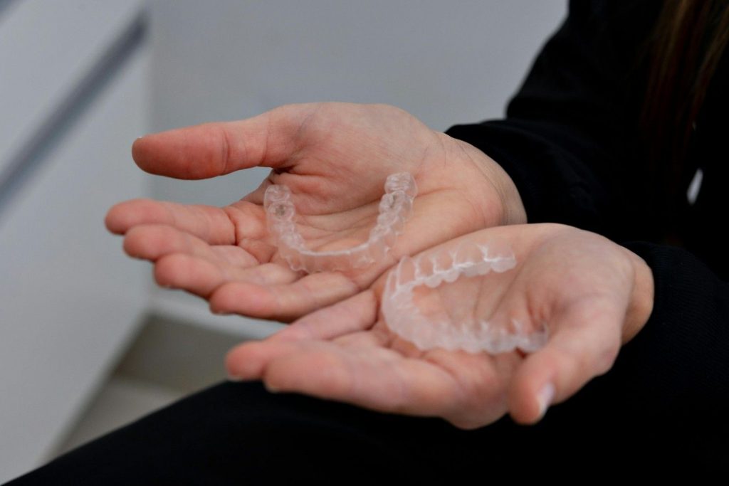 A clear Invisalign on a person’s hands