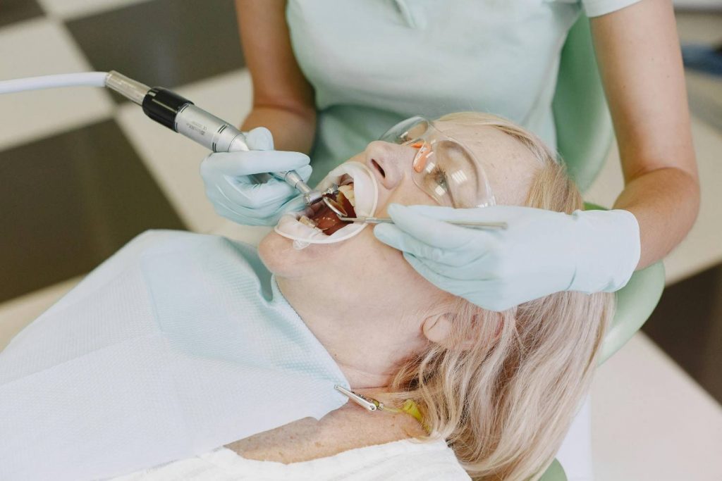 A dentist performs dental treatment on a woman patient