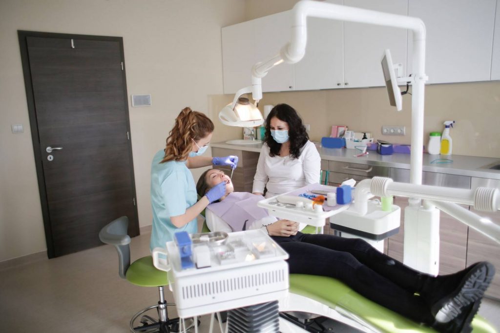 Female dentist performs treatment on a patient in a modern dental clinic