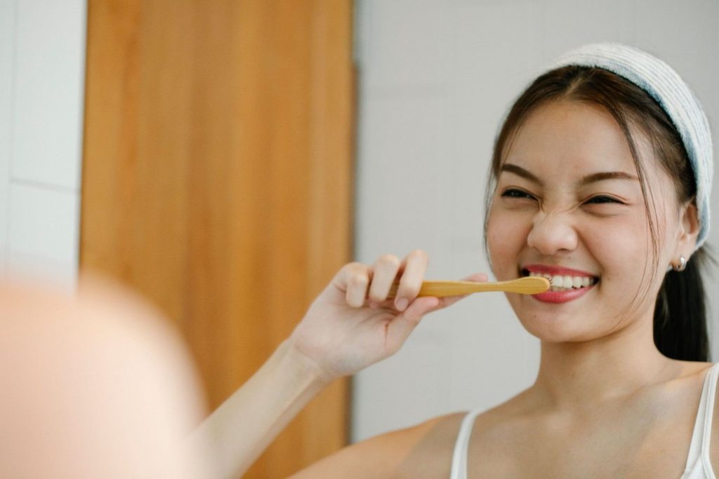 Smiling woman with toothbrush reflects joyful wellness morning routine