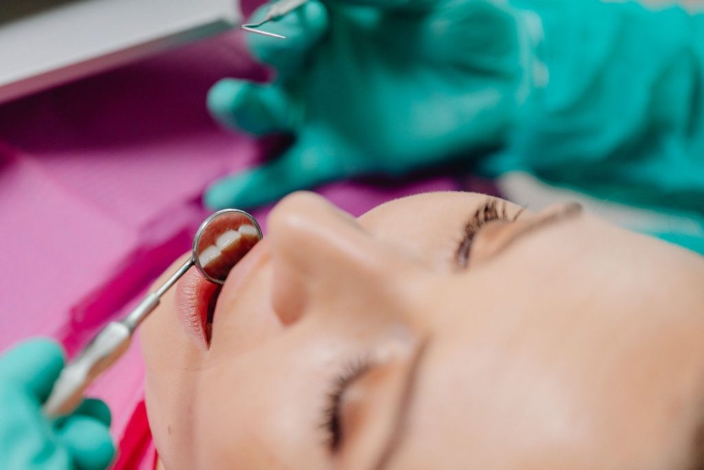 Patient undergoing a dental examination, focusing on tools and technique